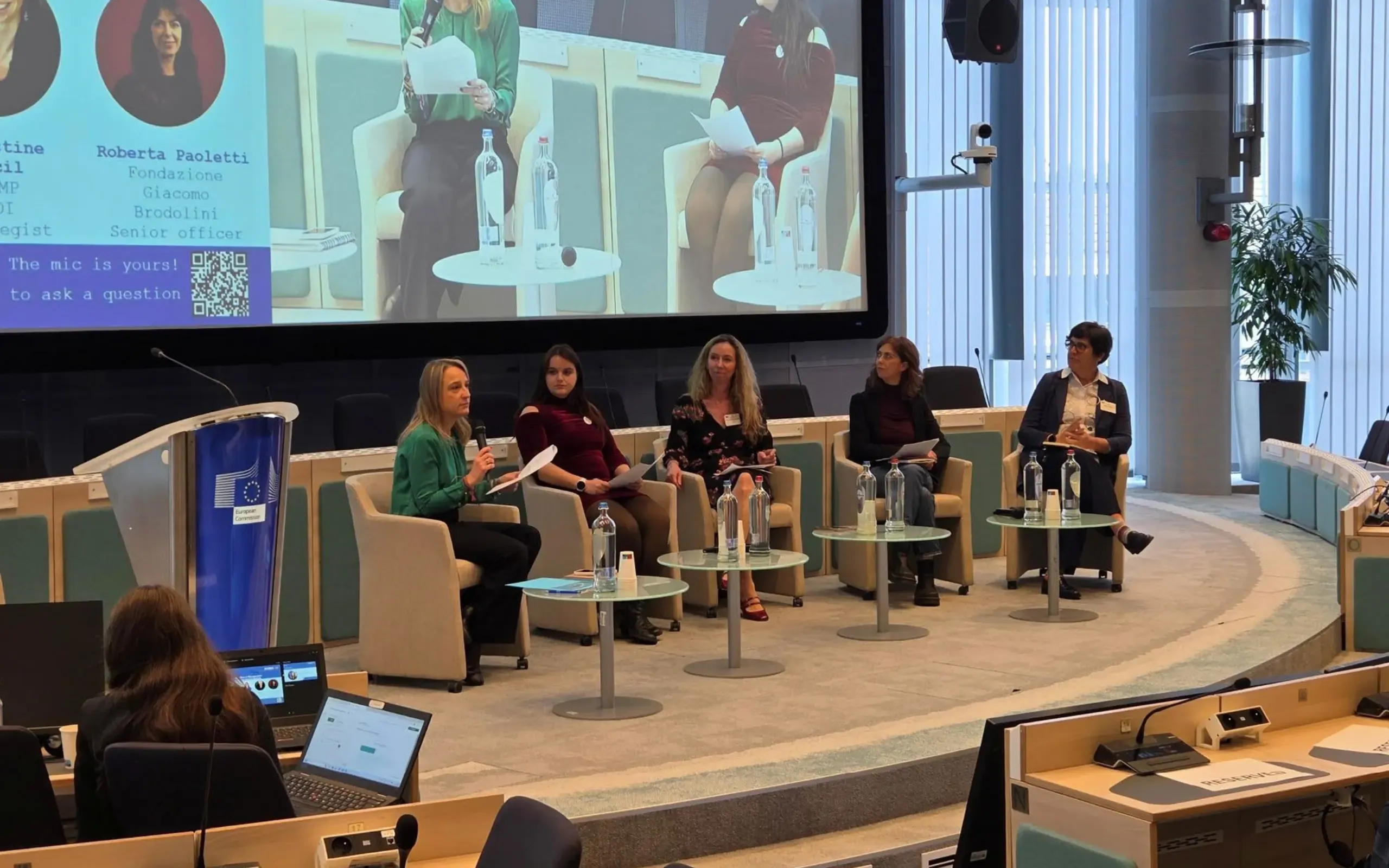 Five panellists seated on stage in front of a large screen during a discussion at the DIVERIS Annual Meeting.