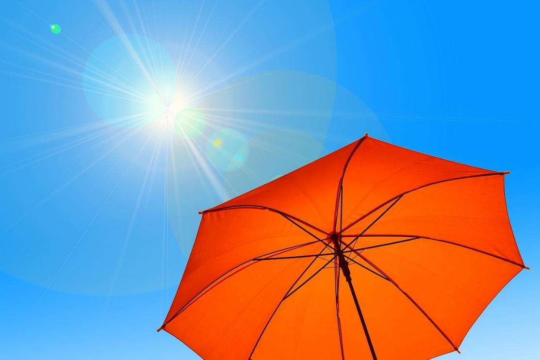An orange umbrella in the air</p>
<p>Description automatically generated
