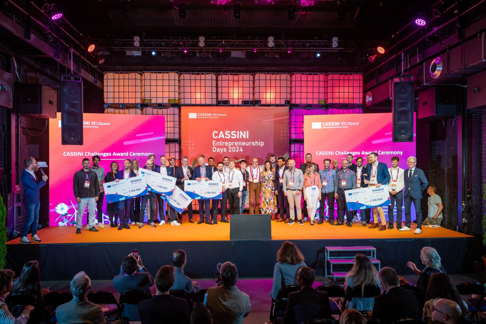 Group photo of winners and participants on stage at the CASSINI Entrepreneurship Days 2024 Award Ceremony holding prize checks.
