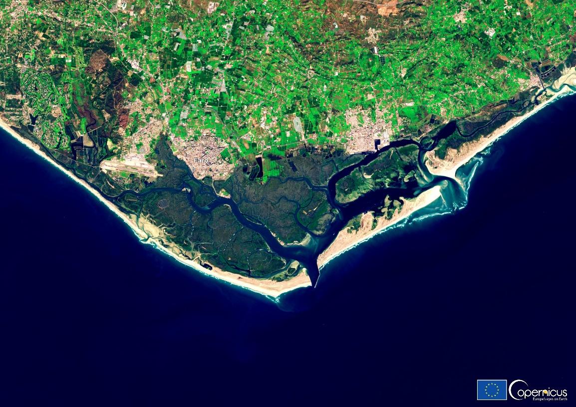 An aerial view of a land with water and land</p>
<p>Description automatically generated