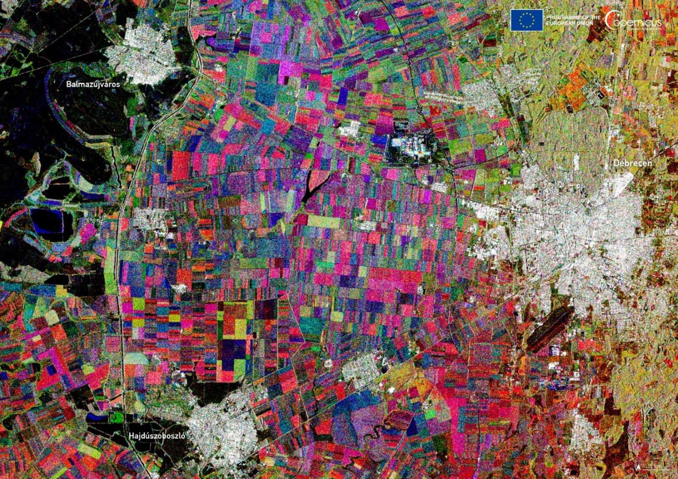 Multitemporal Sentinel-1 radar image from September, October, and November 2023, depicting agricultural activity near Debrecen, Hungary. Reddish, yellow, blue, and magenta areas represent varying crop activity periods, with urban and natural features v...